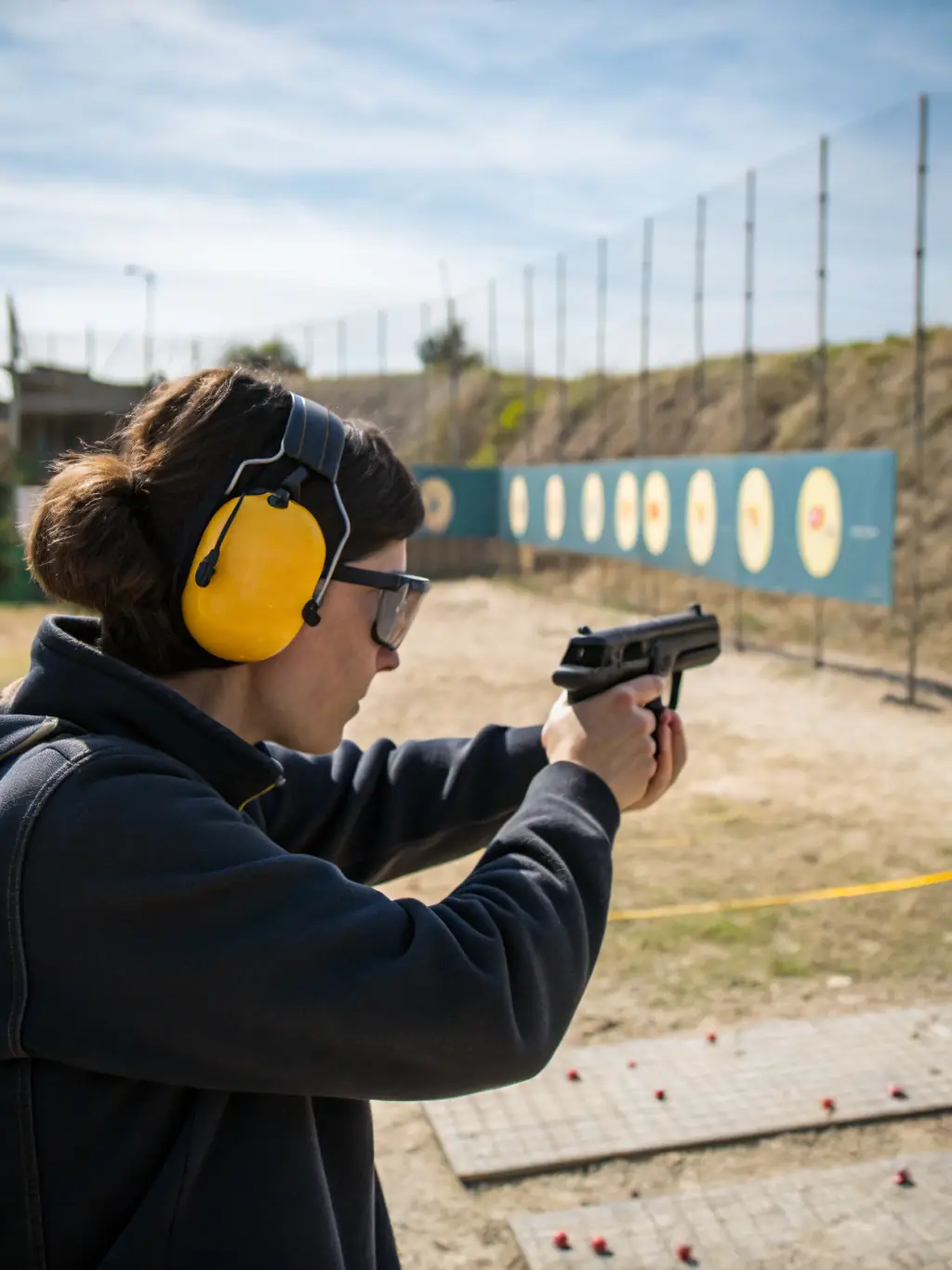 A focused image of a participant in the 'Introduction to Shooting' program, carefully aiming at a target under the guidance of a certified instructor at the CTSC CLUB DE TIR DE SAINT COUTANT.